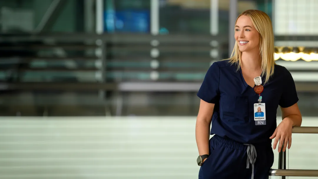 A Nurse Leans on a Railing Smiling