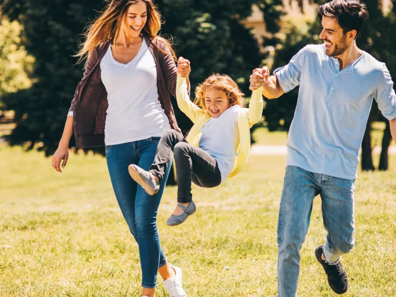Family playing outside together in a park.