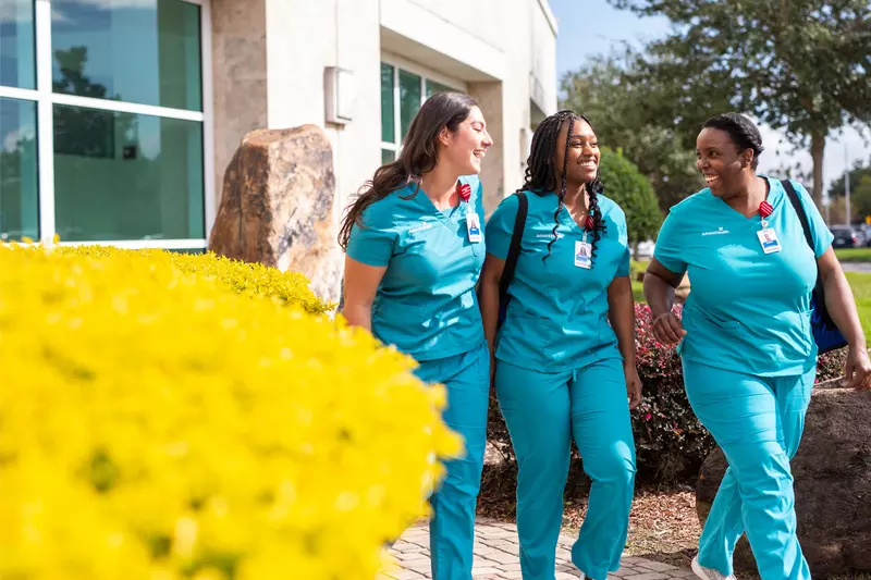 3 nurses walking outside a hospital